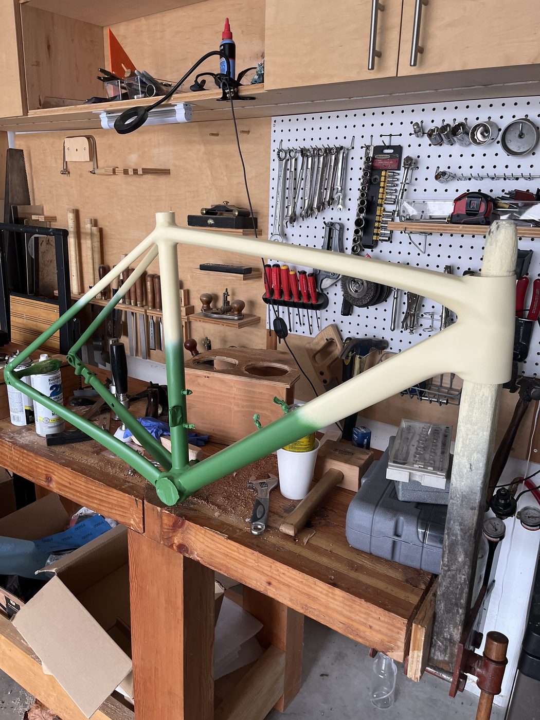 The repainted Emonda frame in a repair stand in the shop, partway through assembly.