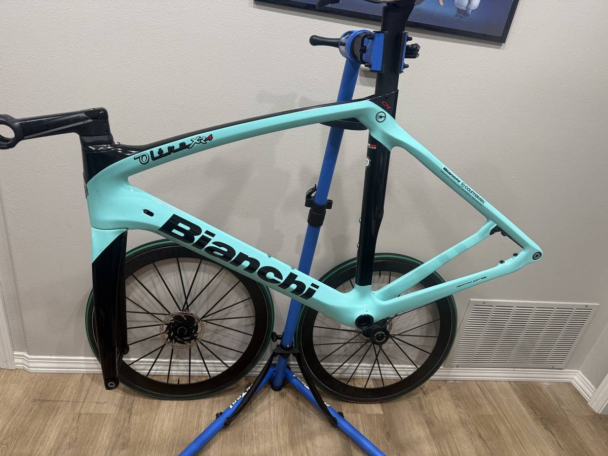 Celeste and black Bianchi Oltre XR4 frame and fork with the black Vision cockpit fitted, on a blue work stand with wheels in, from the seller's Craigslist listing. Photo 9 of 15.
