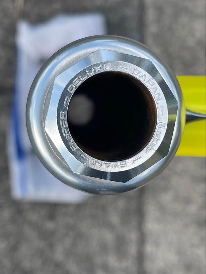 Yellow Bridgestone track frame with a polished silver rear triangle propped on a pavement beside its matching silver fork, from the seller's Marketplace listing. Photo 4 of 5.