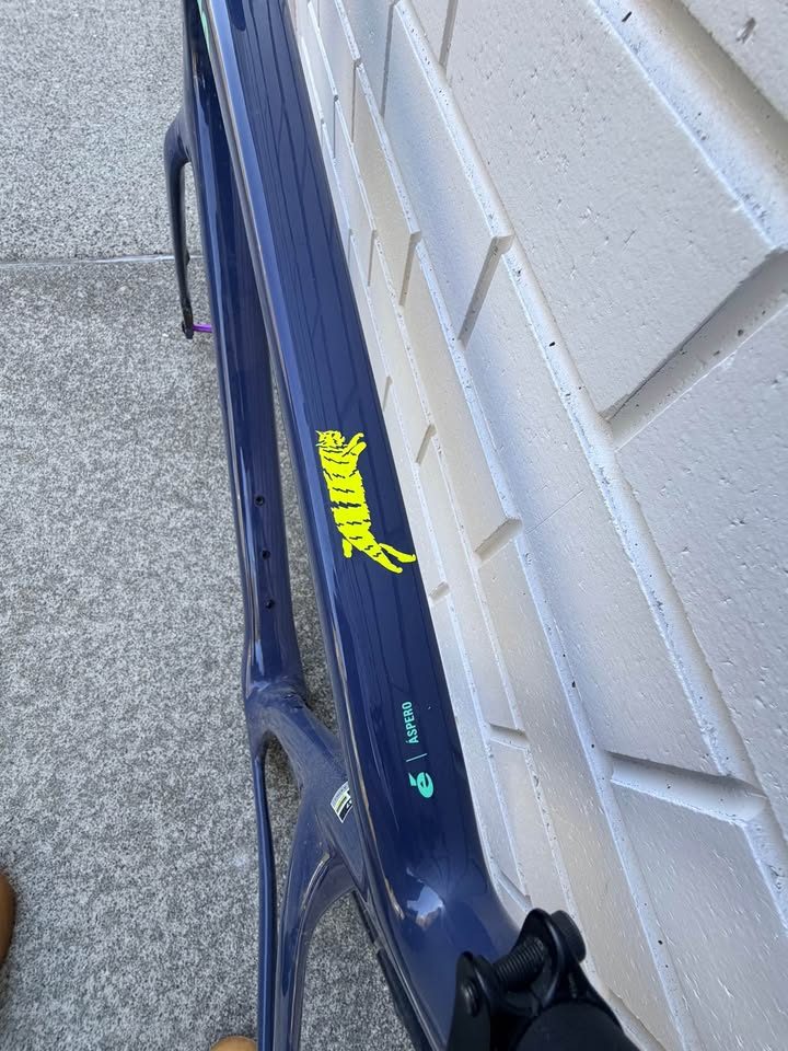 Dark blue Cervélo Áspero frame and fork with a stem and seatpost fitted and purple axles, leaning against a white brick wall, from the seller's Marketplace listing. Photo 5 of 9.