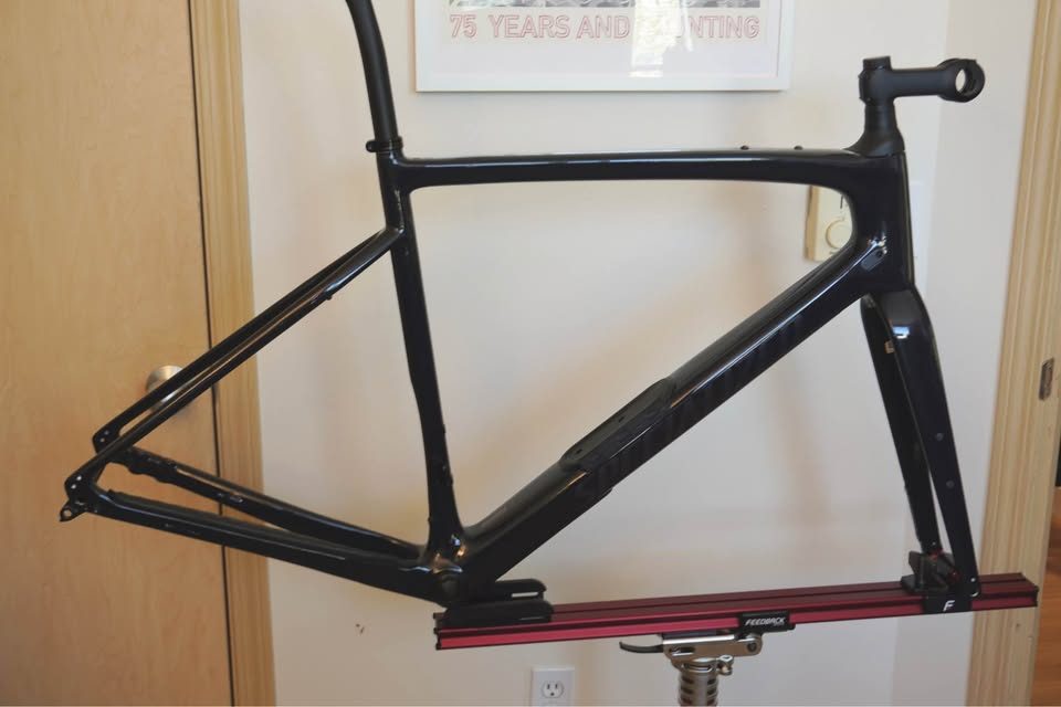 Dark navy Specialized Diverge carbon frame and fork hanging on a workshop stand with the stem fitted and no wheels or drivetrain, from the seller's Marketplace listing.