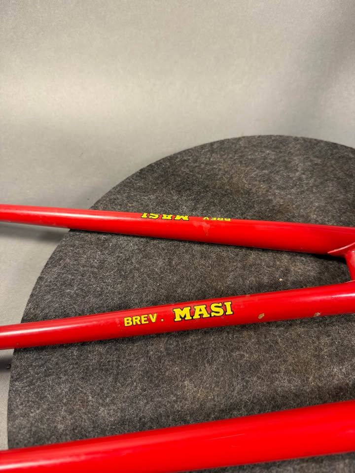 Red lugged steel Masi track frame and matching fork on a grey studio backdrop, MASI in yellow on the down tube and Italian tricolour bands on the seat tube, from the seller's Marketplace listing. Photo 3 of 10.