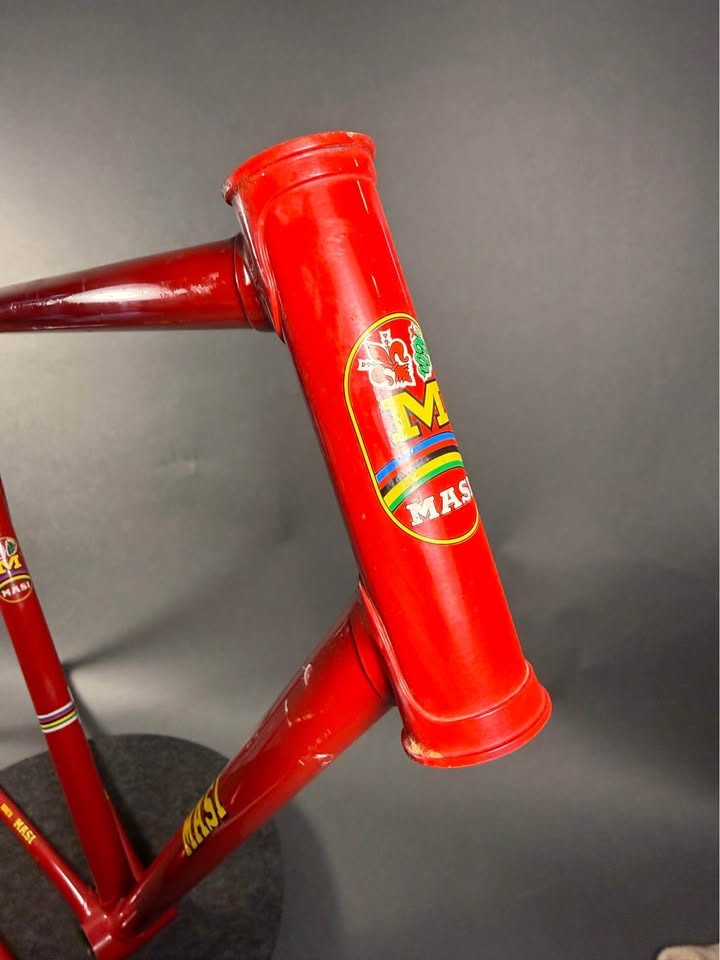 Red lugged steel Masi track frame and matching fork on a grey studio backdrop, MASI in yellow on the down tube and Italian tricolour bands on the seat tube, from the seller's Marketplace listing. Photo 5 of 10.