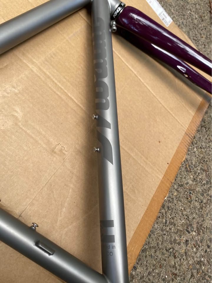 Brushed titanium Mosaic road frameset laid out on cardboard next to its purple carbon fork, from the seller's Marketplace listing. Photo 2 of 8.