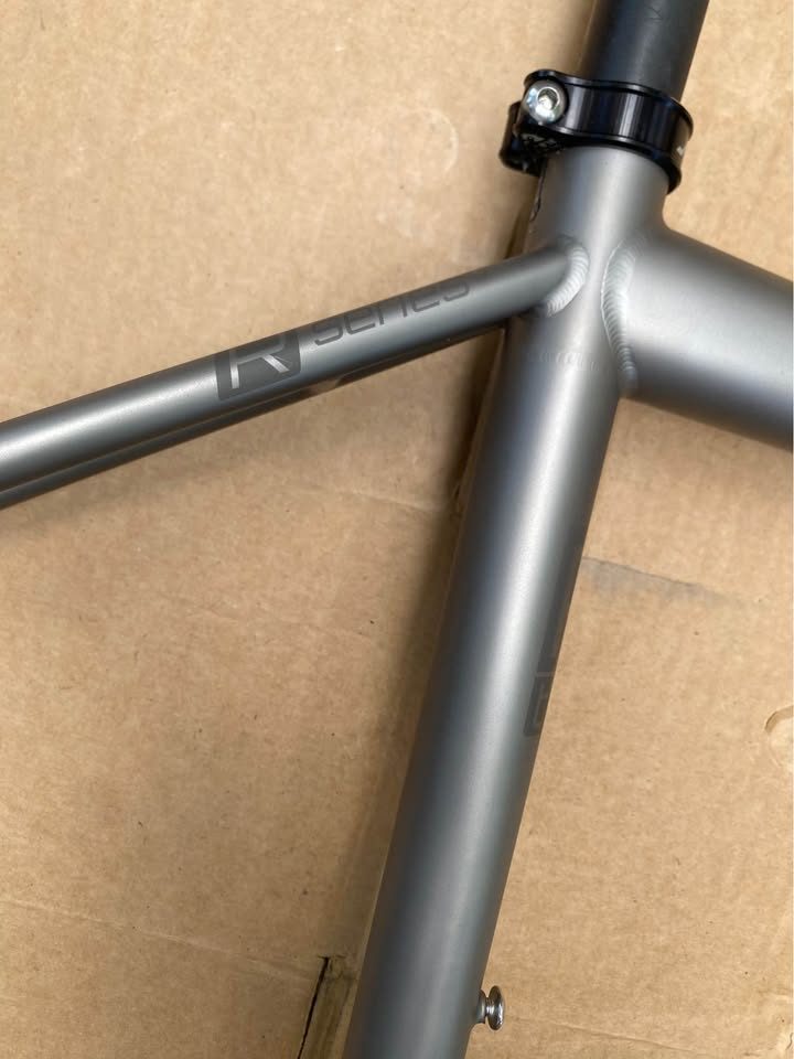 Brushed titanium Mosaic road frameset laid out on cardboard next to its purple carbon fork, from the seller's Marketplace listing. Photo 3 of 8.