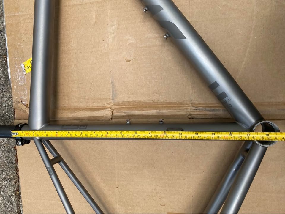 Brushed titanium Mosaic road frameset laid out on cardboard next to its purple carbon fork, from the seller's Marketplace listing. Photo 7 of 8.