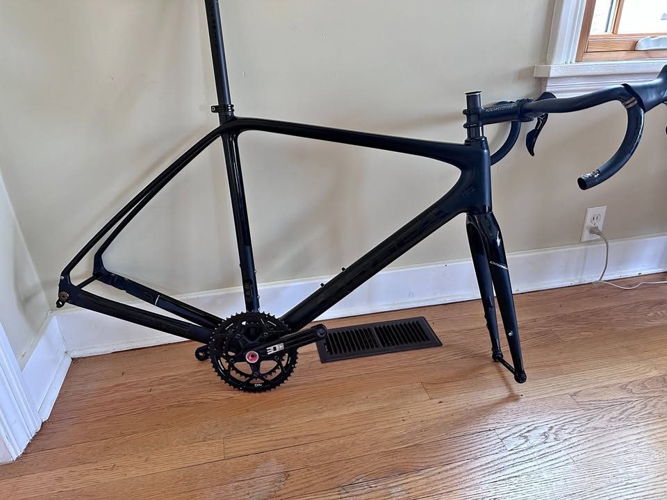 Black Orbea Terra carbon frame and fork with a Rotor crankset fitted and a handlebar and stem on the fork, standing on a wood floor, from the seller's Marketplace listing.