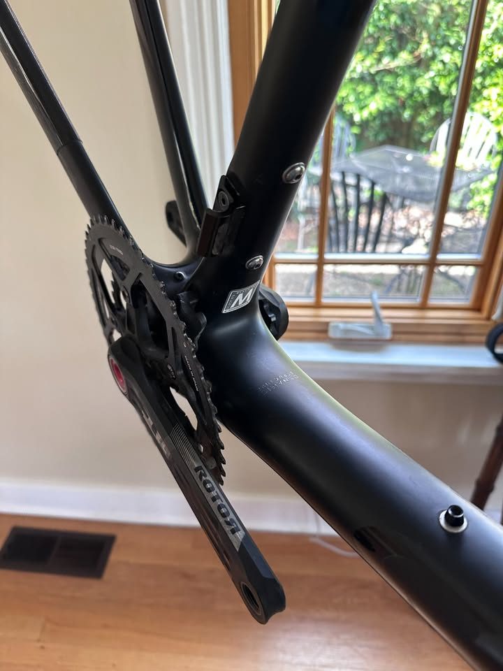 Black Orbea Terra carbon frame and fork with a Rotor crankset fitted and a handlebar and stem on the fork, standing on a wood floor, from the seller's Marketplace listing. Photo 3 of 10.