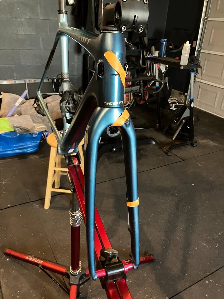 Blue-green Scott carbon frame and fork in a work stand in a garage, with a seatpost, stem and SRAM rear derailleur fitted, from the seller's Marketplace listing. Photo 4 of 6.